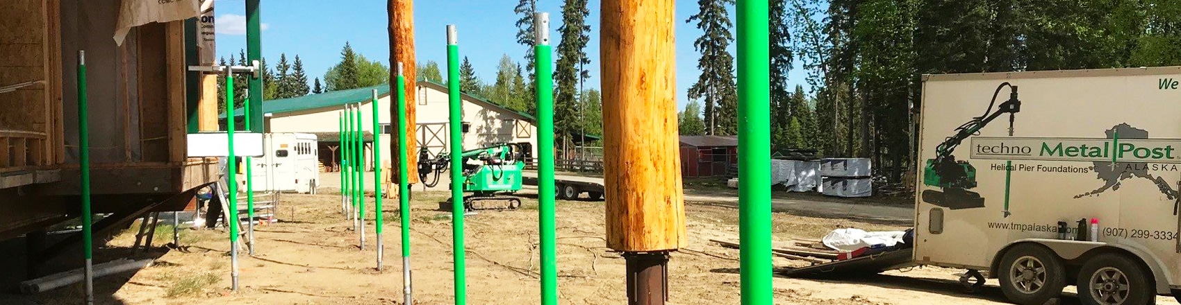 Metal posts lined up in the ground and ready to be installed.